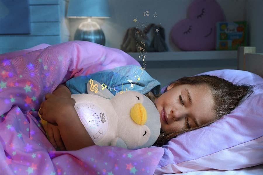 meisje in bed met knuffelpinguin